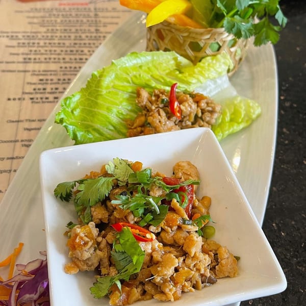 Thai lettuce wraps with minced chicken, chili, and cilantro, served with fresh lettuce and vegetables.